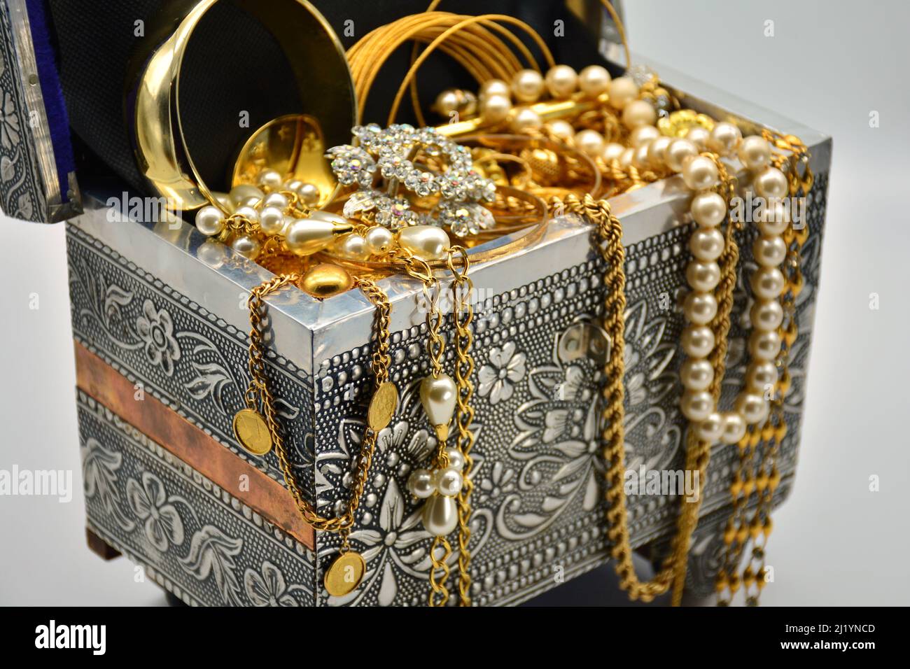 Un tesoro, cofre lleno de joyas, perlas, y oro, sobre fondo blanco Stock Photo