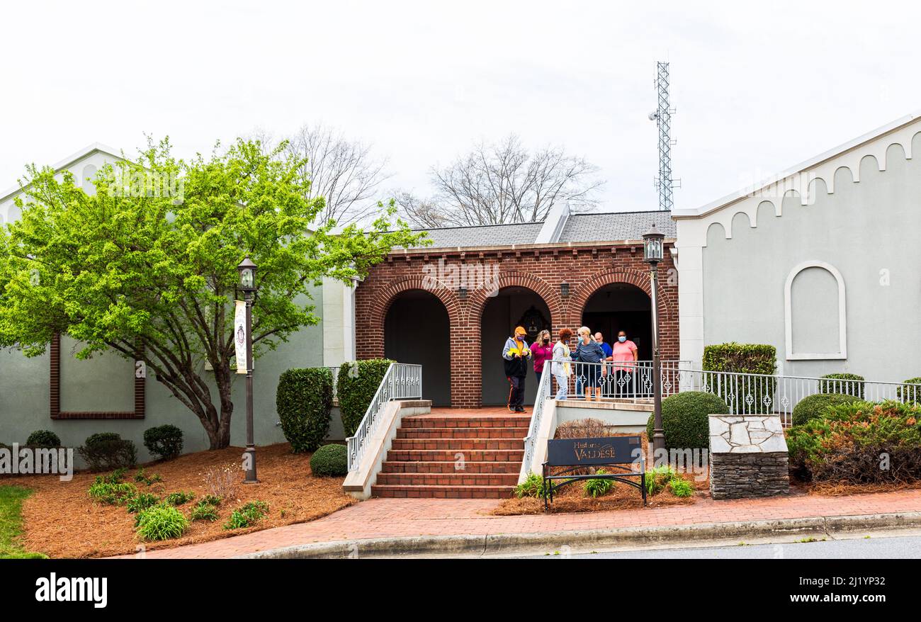 VALDESE, NC, USA-24 MARCH 2022: Entrance to the Waldensian Heritage Museum, with six people exiting and conversing. Stock Photo