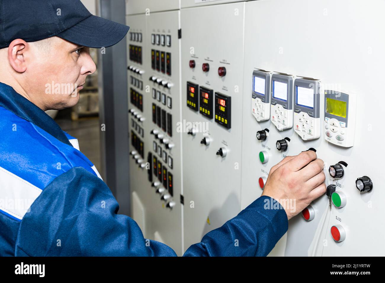 Hand pressing on green button of the machine in the factory Stock Photo