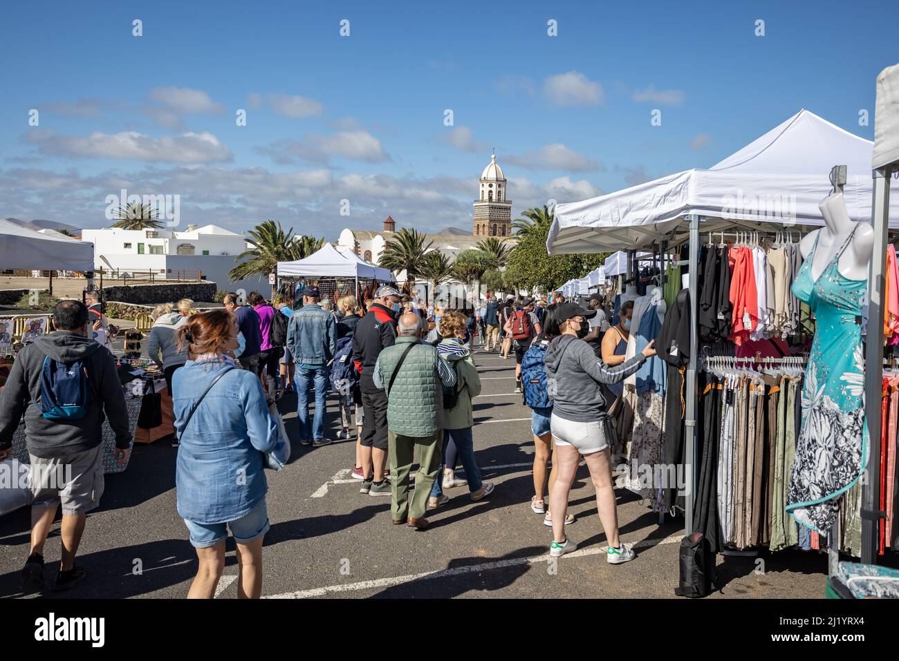Shoppers at Teguise Sunday market with church in background in Teguise