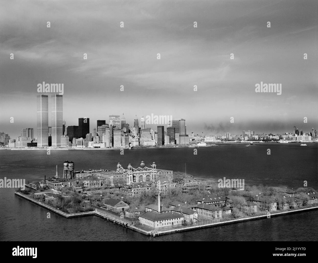 Ellis Island with Manhattan Skyline in background, World Trade Center Towers to left, New York City, New York, USA, Historic American Buildings Survey Collection, 1970's Stock Photo
