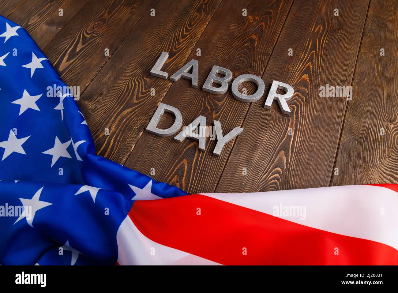 words labor day laid with silver metal letters on wooden surface with