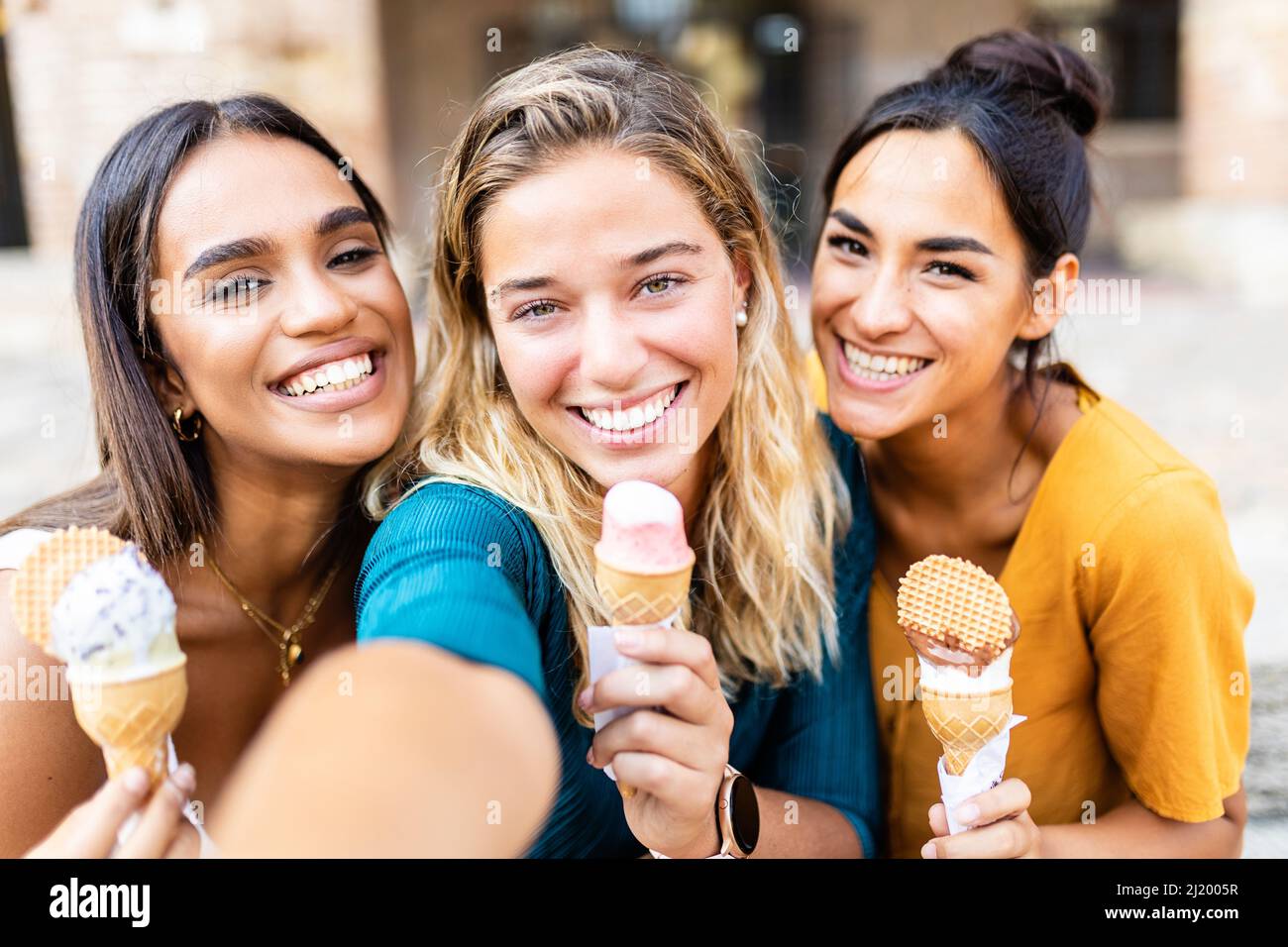 Diverse young women friends taking selfie together while eating an ice cream Stock Photo