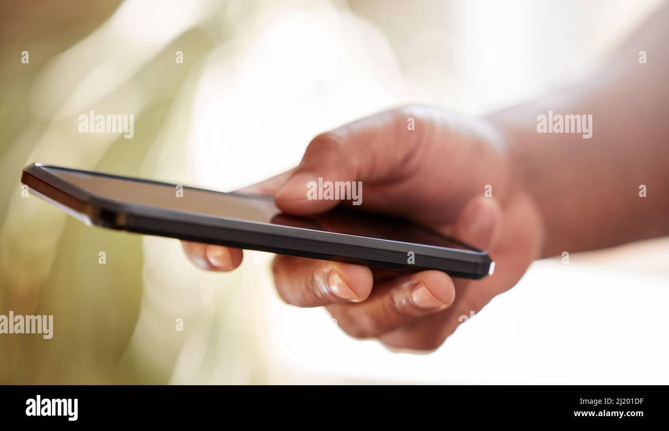 It all starts with a phonecall. Cropped shot of an unrecognizable businessman sending a text message while working on the office. Stock Photo