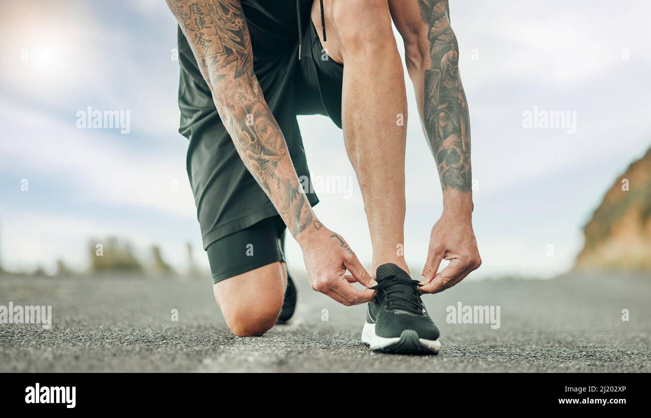 Take on the journey of life. Shot of an unrecognizable person tying their shoelaces before a run. Stock Photo