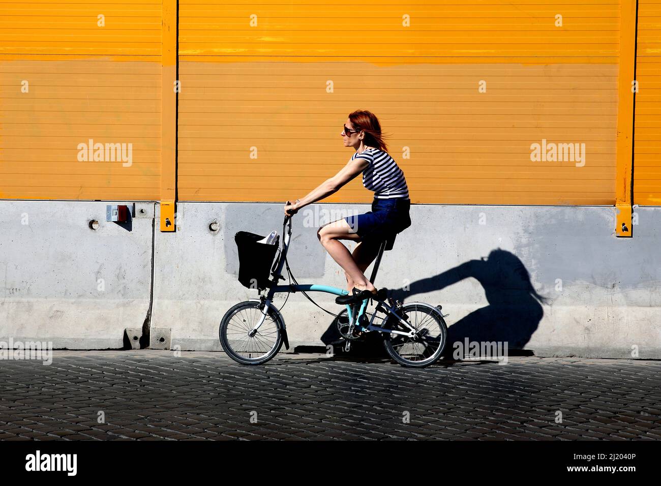 Italy. Rome. Girl riding bike on cobbled street in Rome Stock Photo
