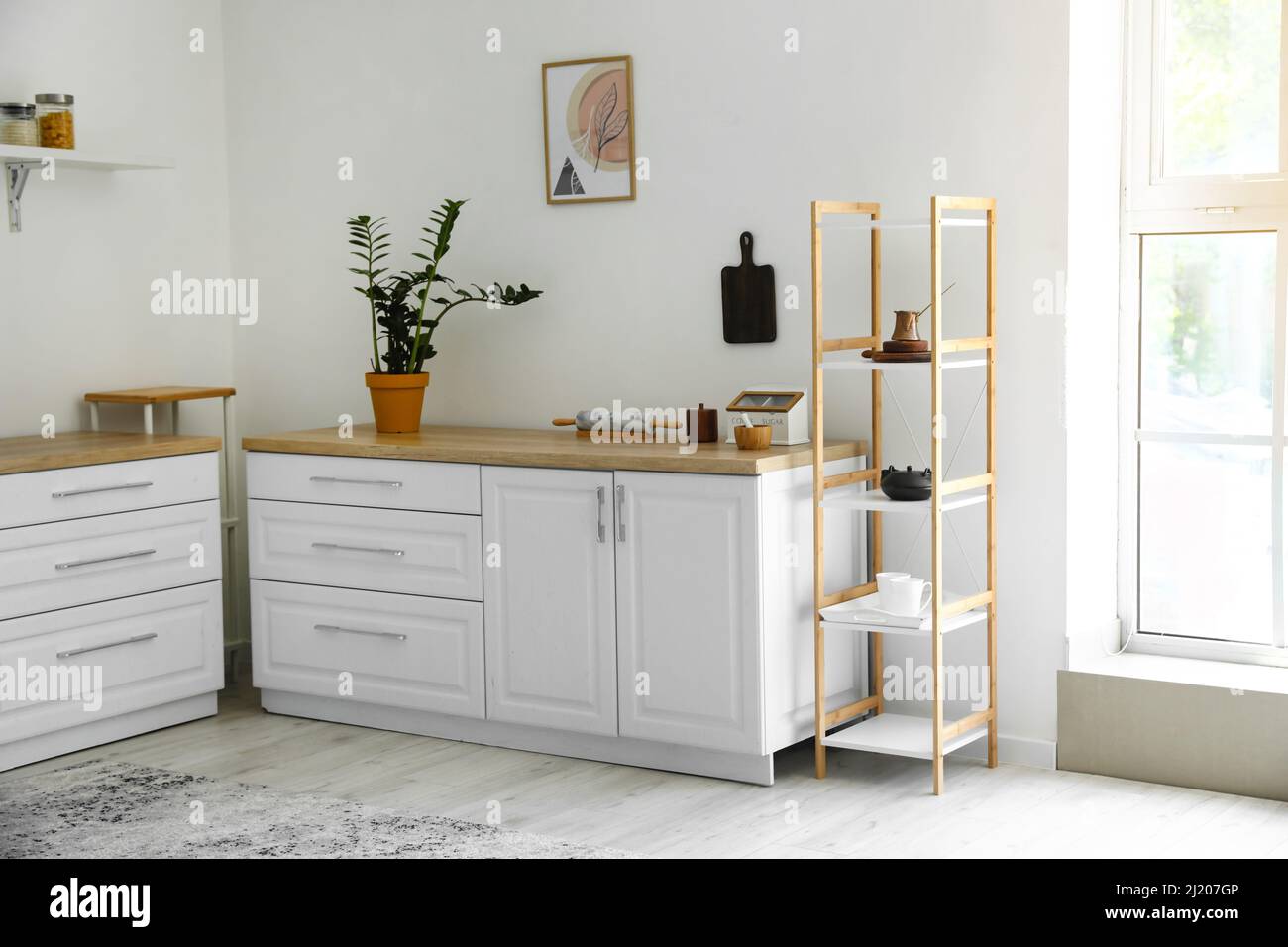 Interior of light modern kitchen with shelf unit Stock Photo - Alamy