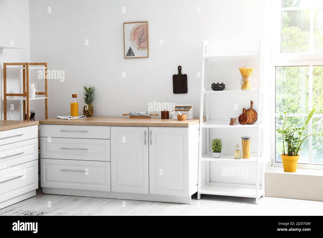 Interior of light modern kitchen with shelf unit Stock Photo - Alamy