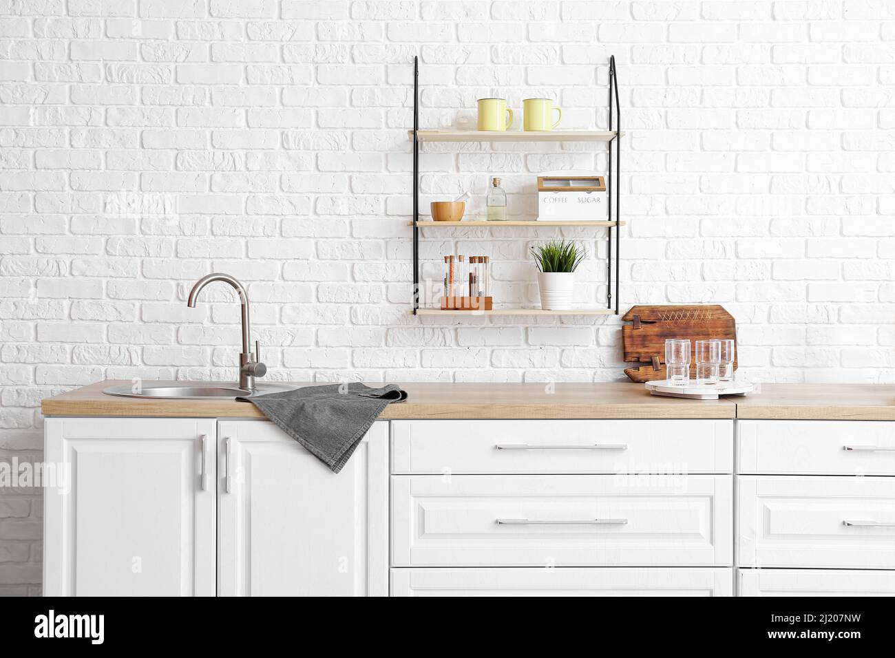 Interior of modern kitchen with white counters and empty glasses Stock ...