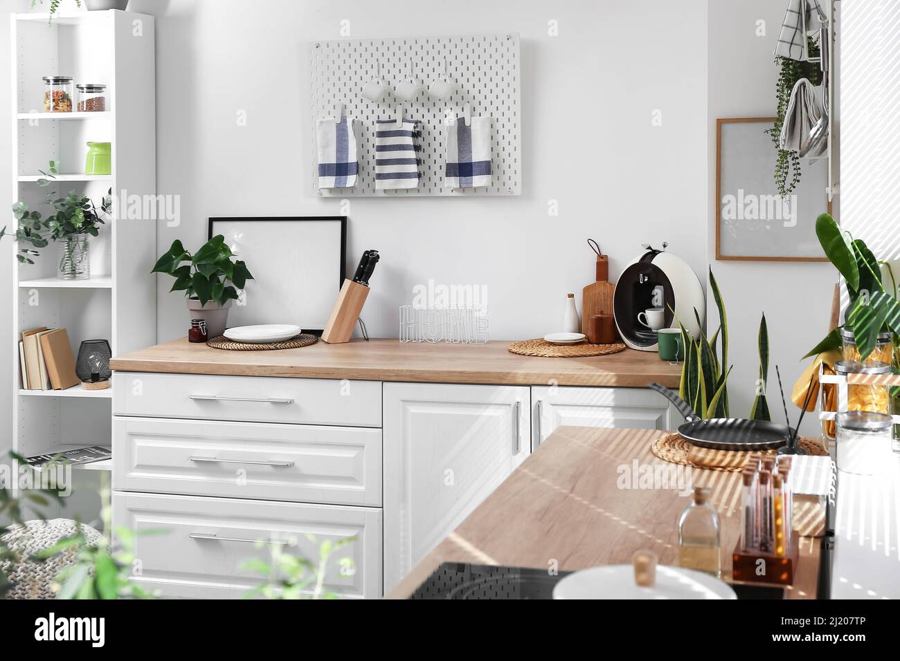 Interior of stylish kitchen with modern furniture and pegboard on light ...