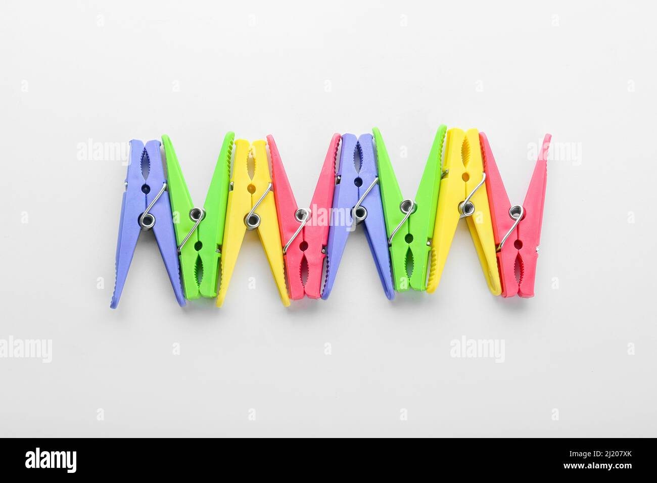 Plastic clothes pins on light background Stock Photo