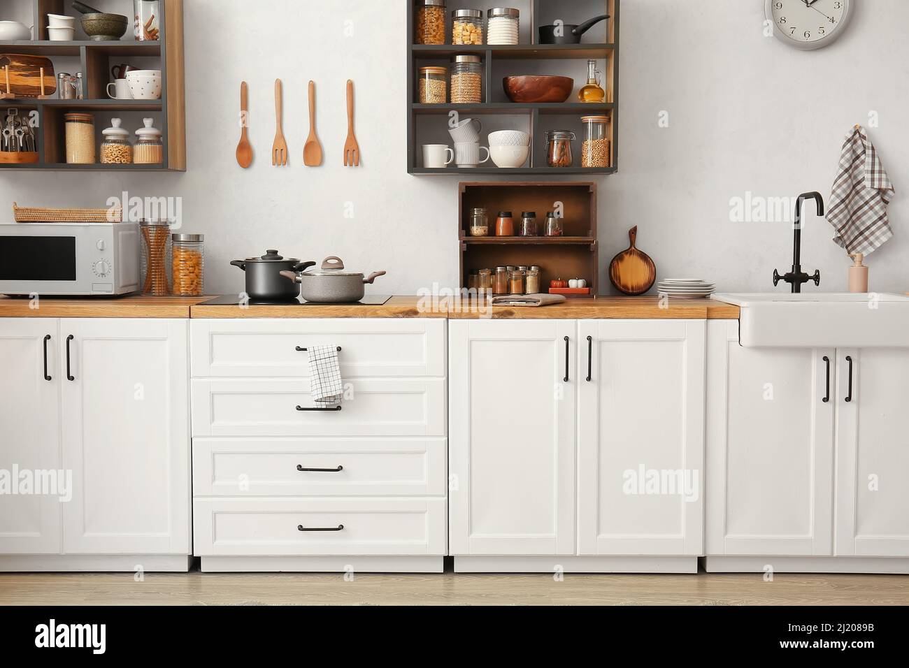 Interior of light modern kitchen with white counters and shelves Stock ...