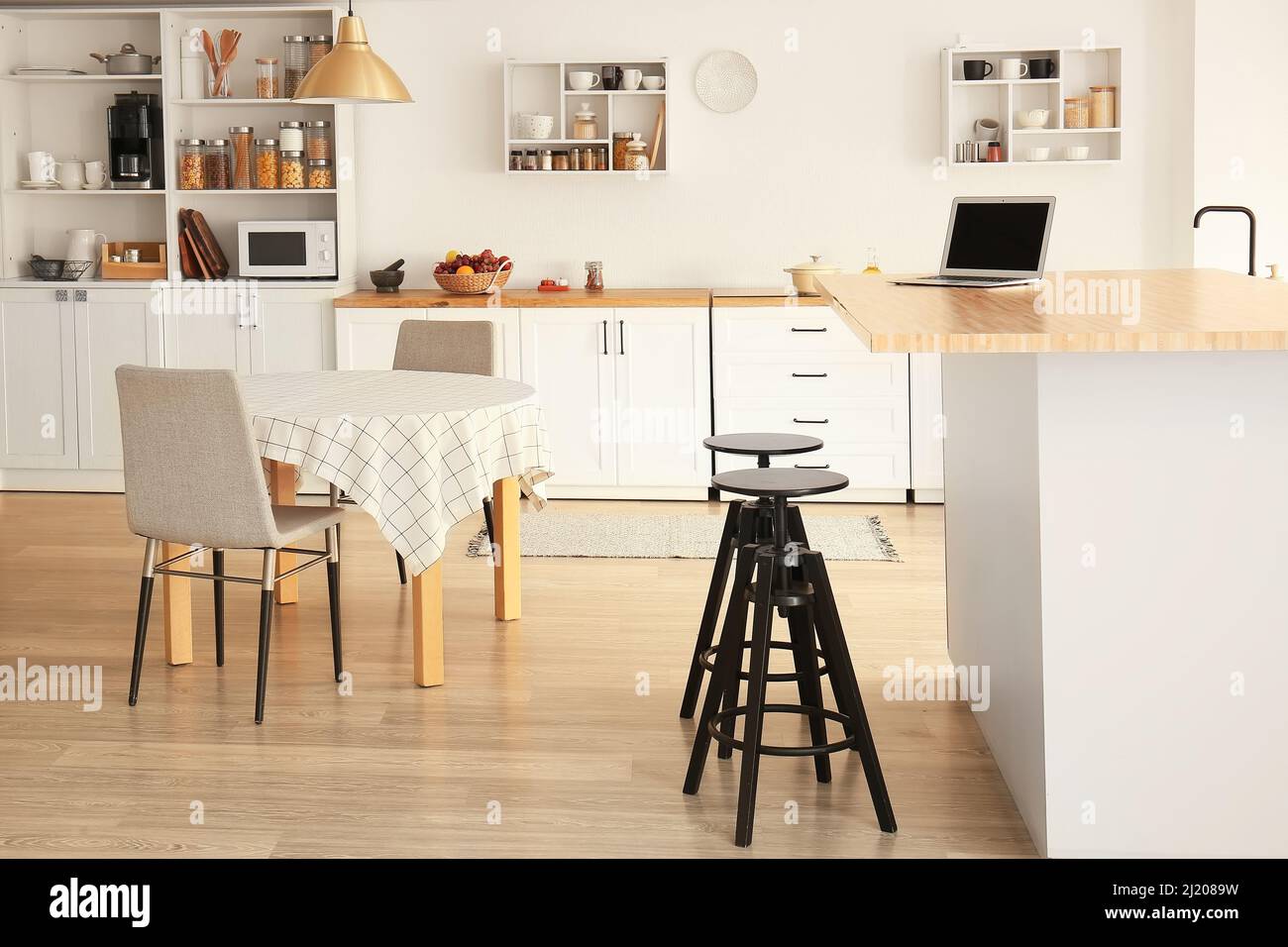 Interior of light modern kitchen with white counters, shelves and ...
