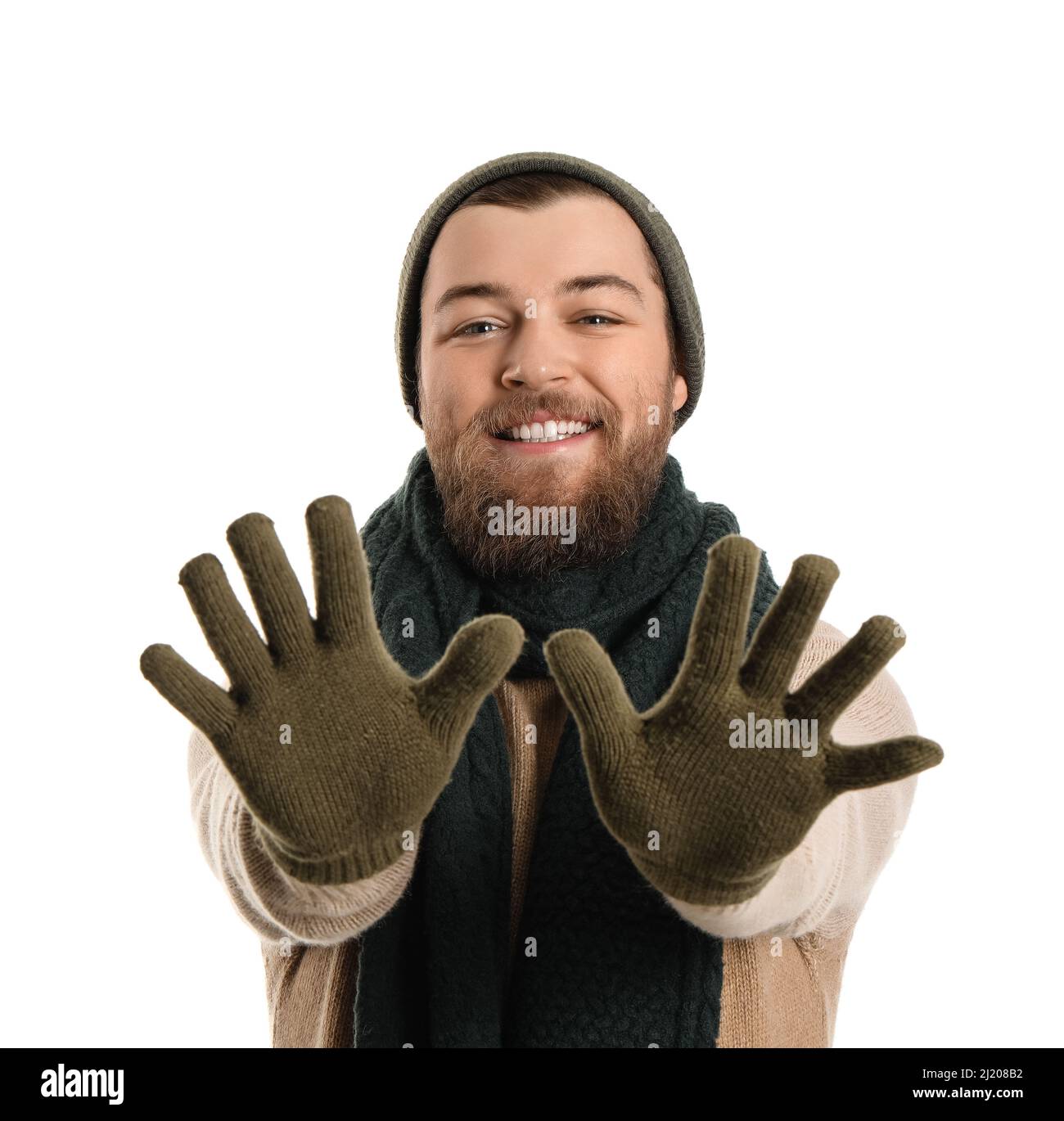 Young bearded man in warm gloves, hat and scarf on white background Stock Photo