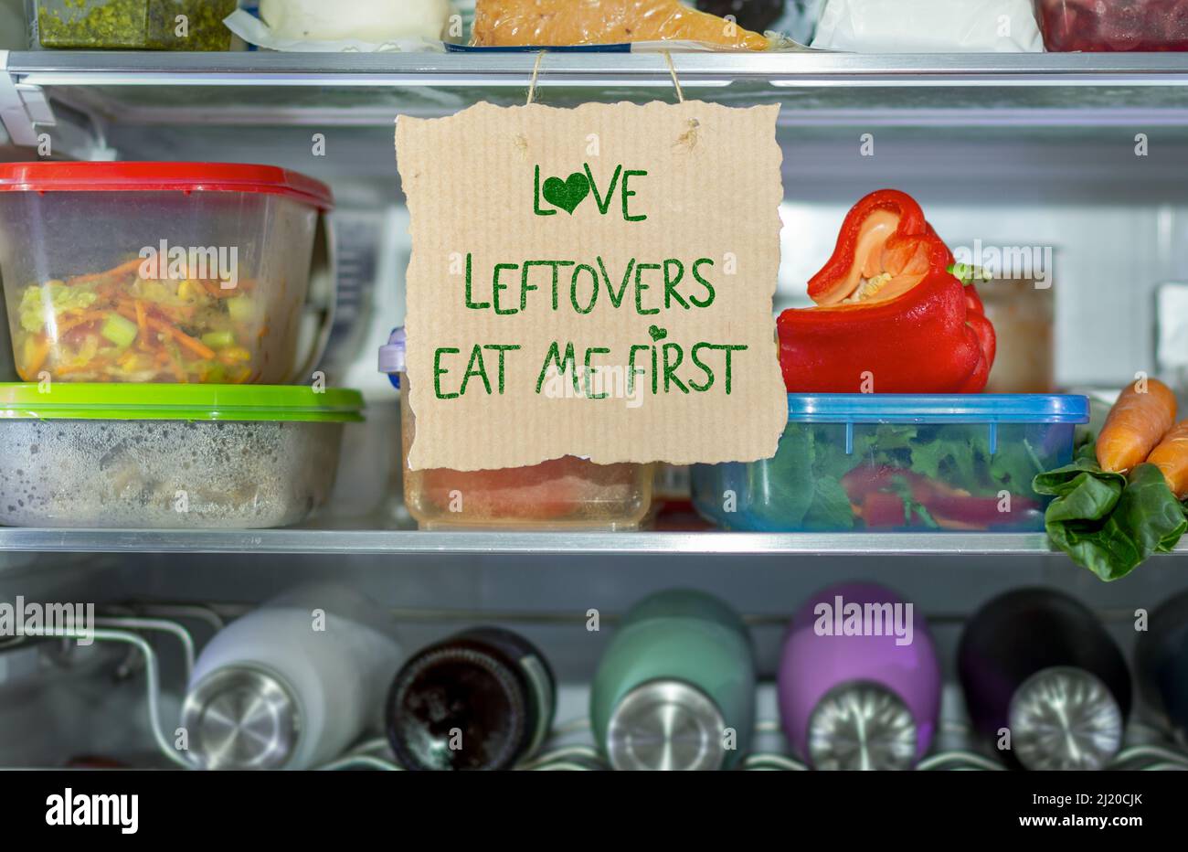 Love Leftovers Eat Me First handmade sign in fridge,  help reduce food waste, know where to look first, simple reduce food waste concept. Stock Photo