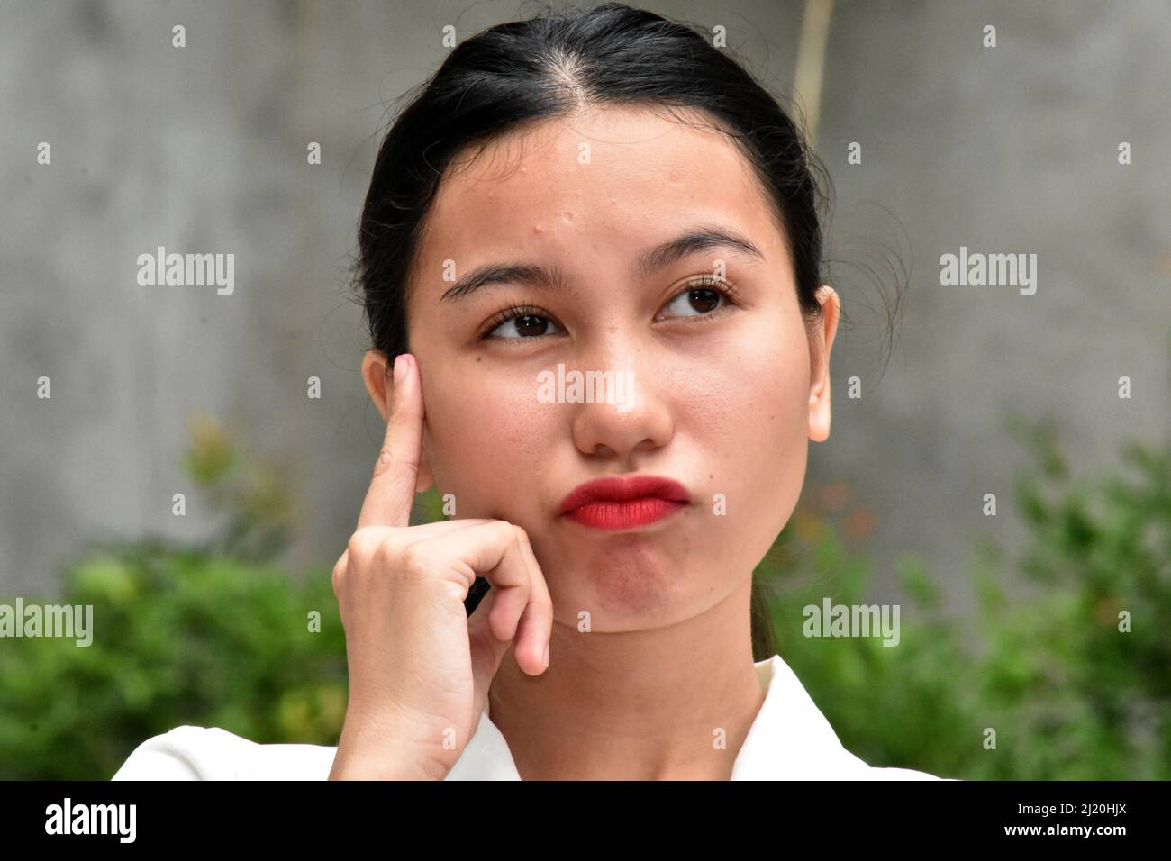 A Confused Asian Woman Thinking Stock Photo