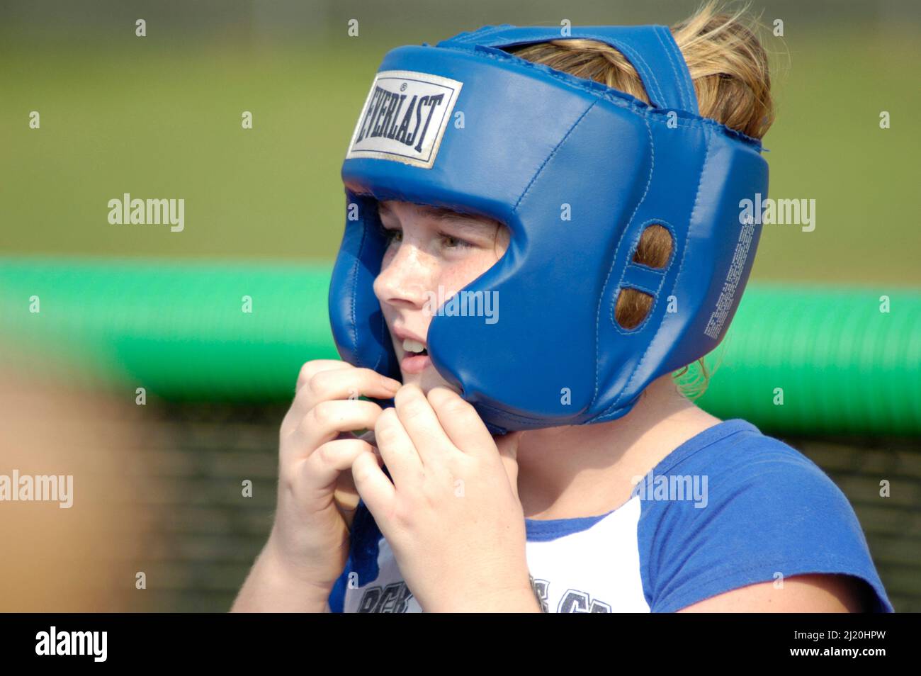 Boy with boxing head gear on for protections from hits and shots to the