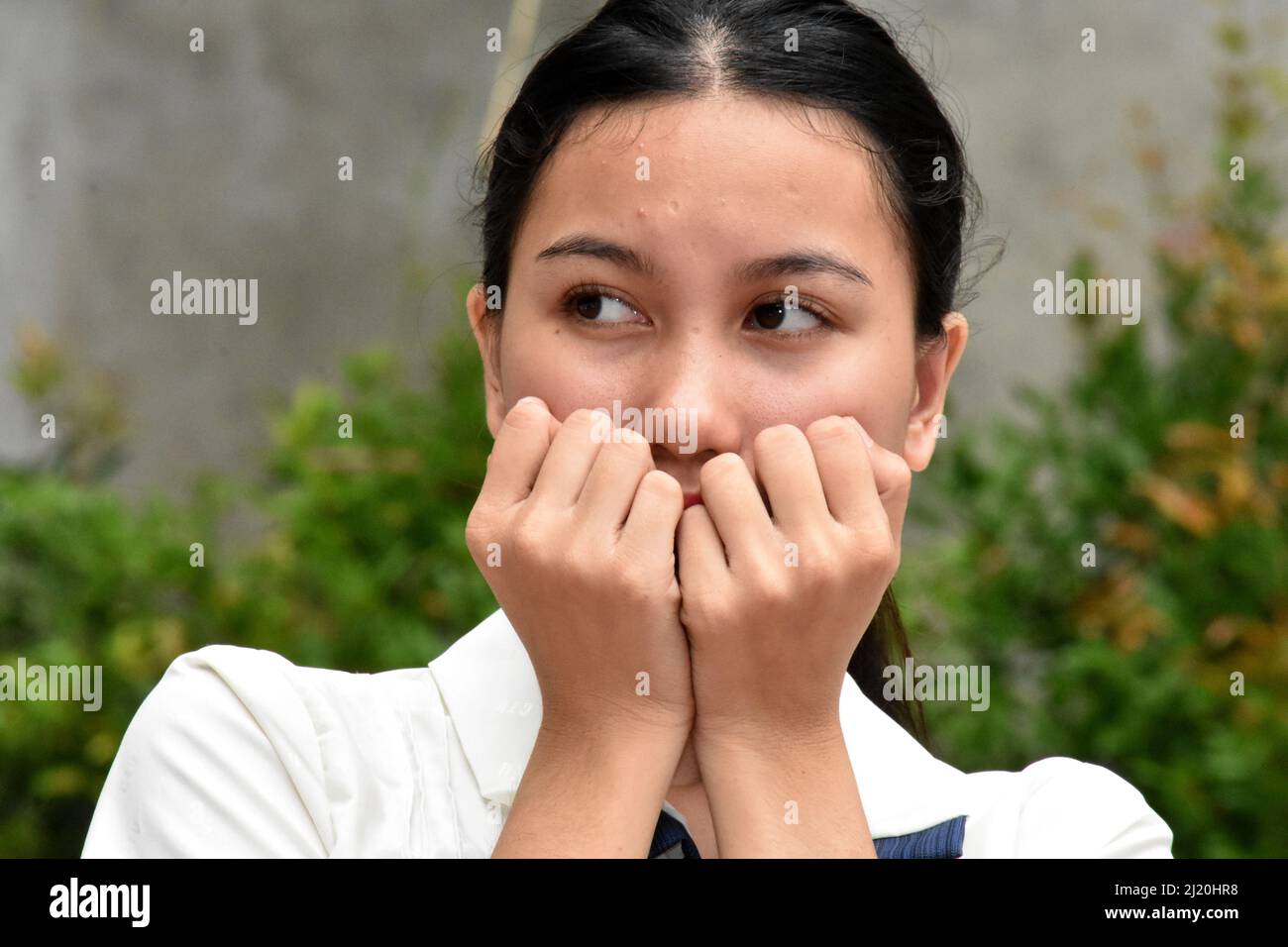 A Shy Or Fearful Asian Woman Stock Photo