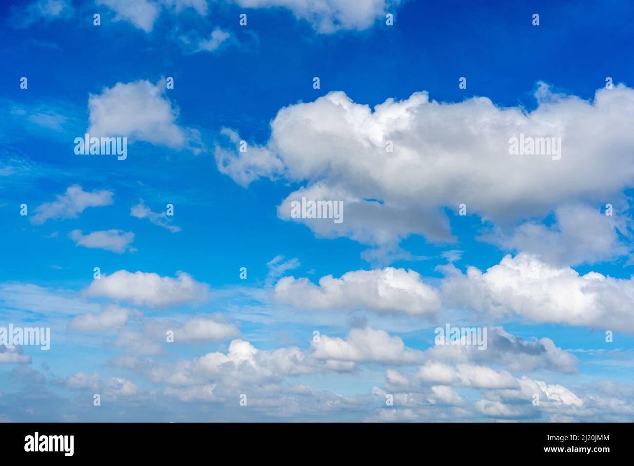 Blue sky with white cumulus clouds floating Stock Photo - Alamy