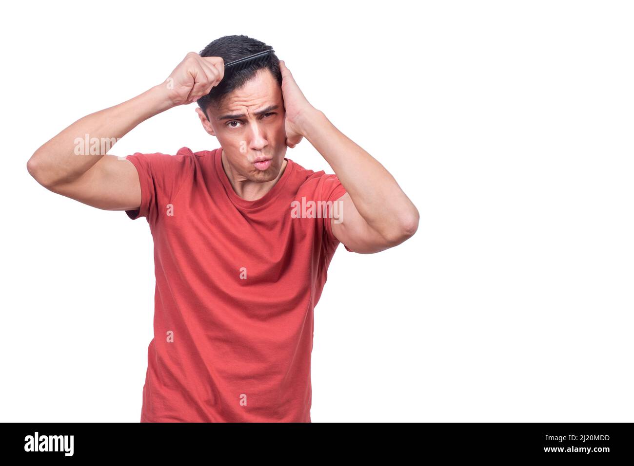 Guy touching head and brushing hair in studio Stock Photo