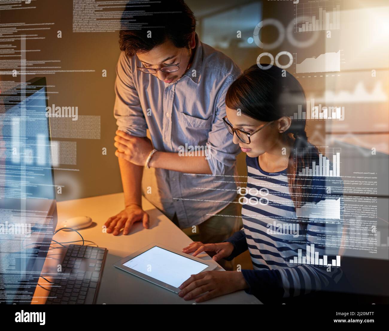Using different devices to crack these codes. Shot of computer programmers looking through data in the office. Stock Photo