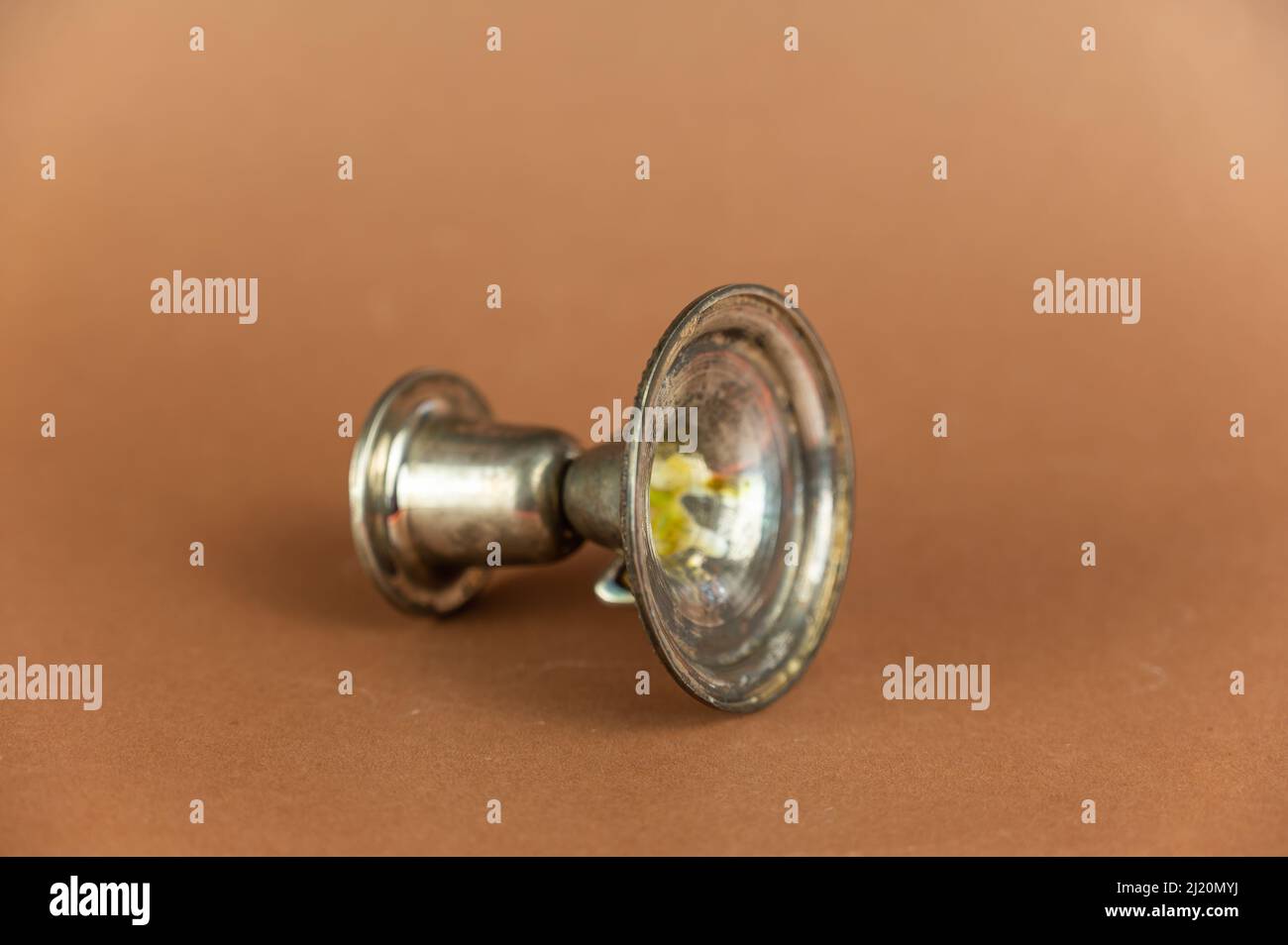 An empty old candlestick against a brown background. Melchior alloy ...