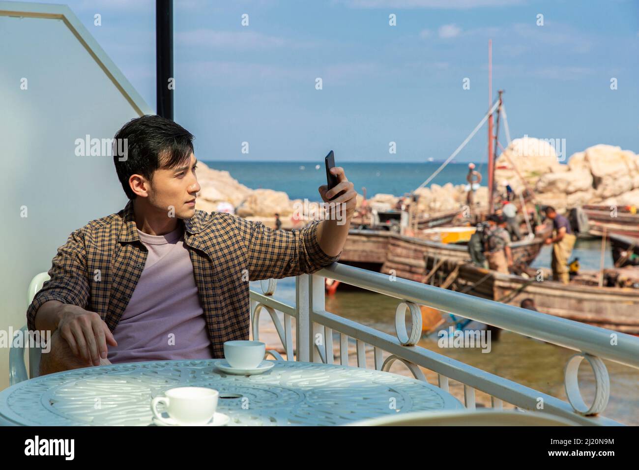 Young man taking photos on beach - stock photo Stock Photo