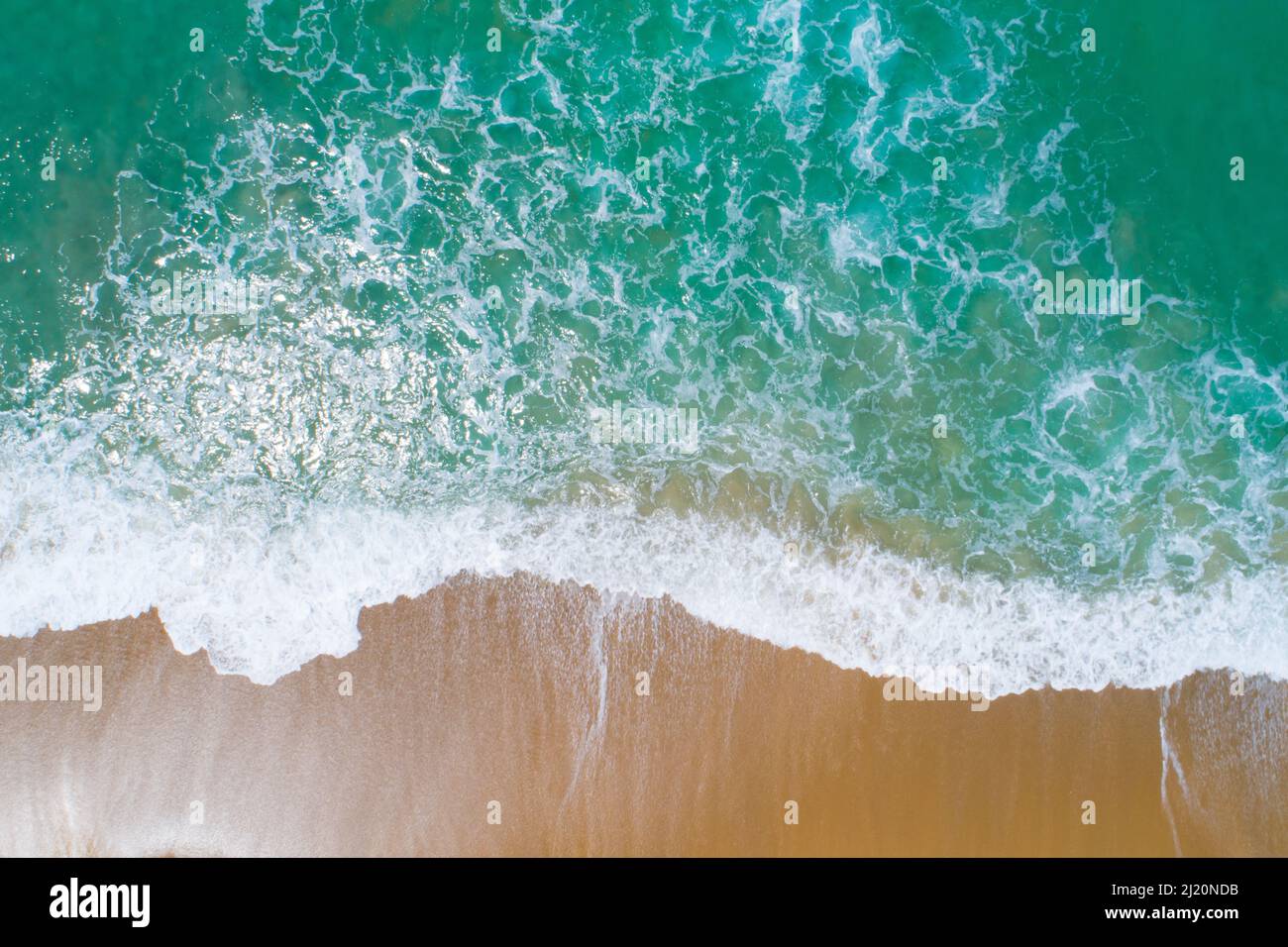 Aerial view sandy beach and waves crashing on sand. Beautiful tropical sea in the morning summer season image by Aerial view drone shot, high angle vi Stock Photo