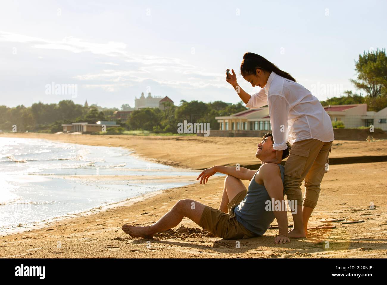 A young couple taking pictures on a summer beach - stock photo Stock Photo