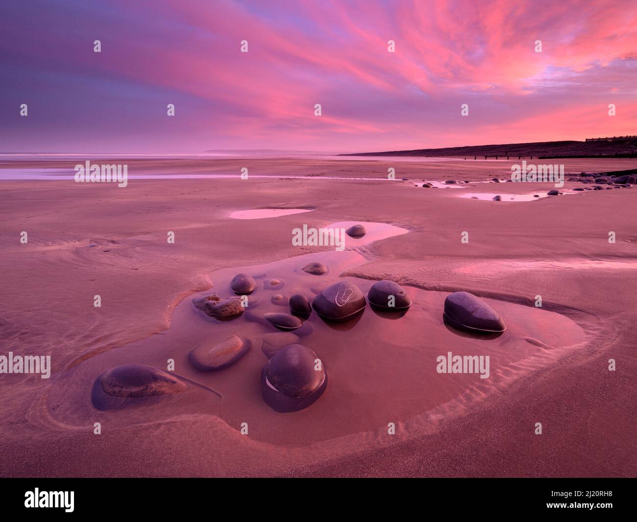 Westward Ho! beach at sunrise, colourful sky at low tide and tidal pool, north Devon, UK. February. Stock Photo