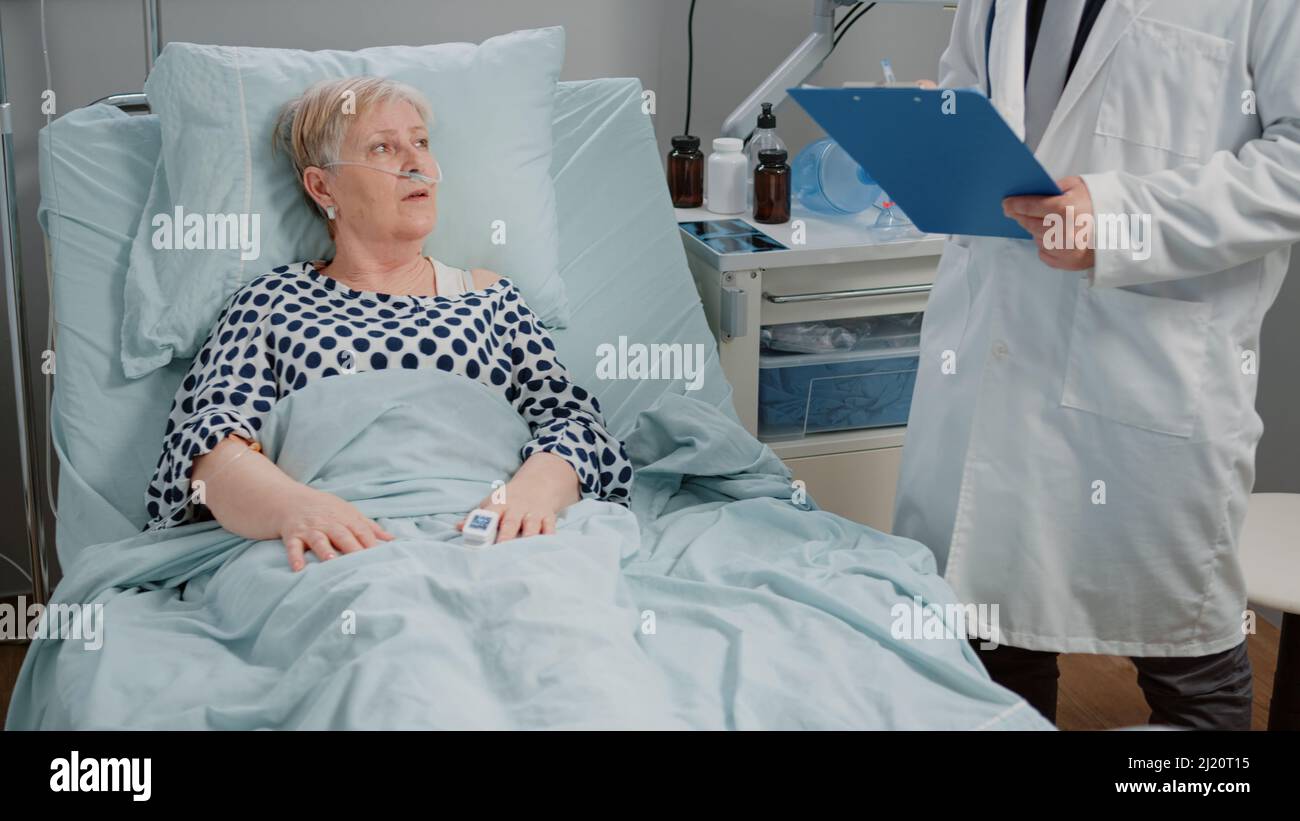 Doctor talking to senior patient with oximeter for examination and