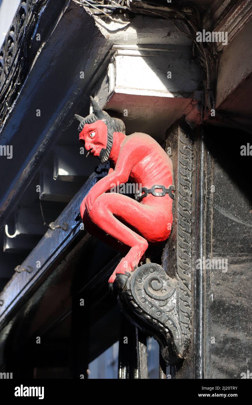 The devil as a support on an old building Stock Photo