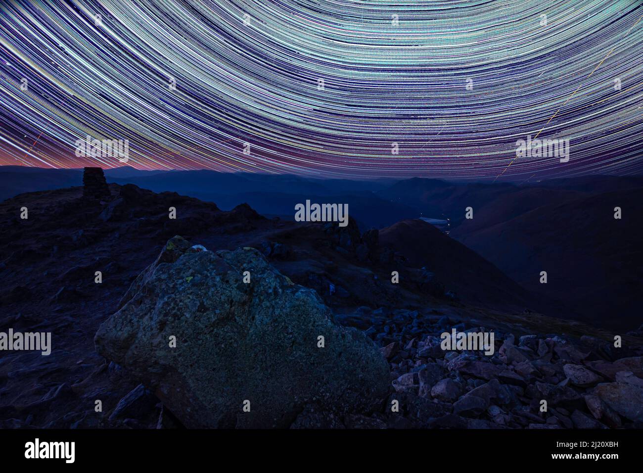 Star trails on Red Screes in Lake District, Cumbria, UK. Beautiful nightscape scene in the mountains. Night under the stars. Stock Photo