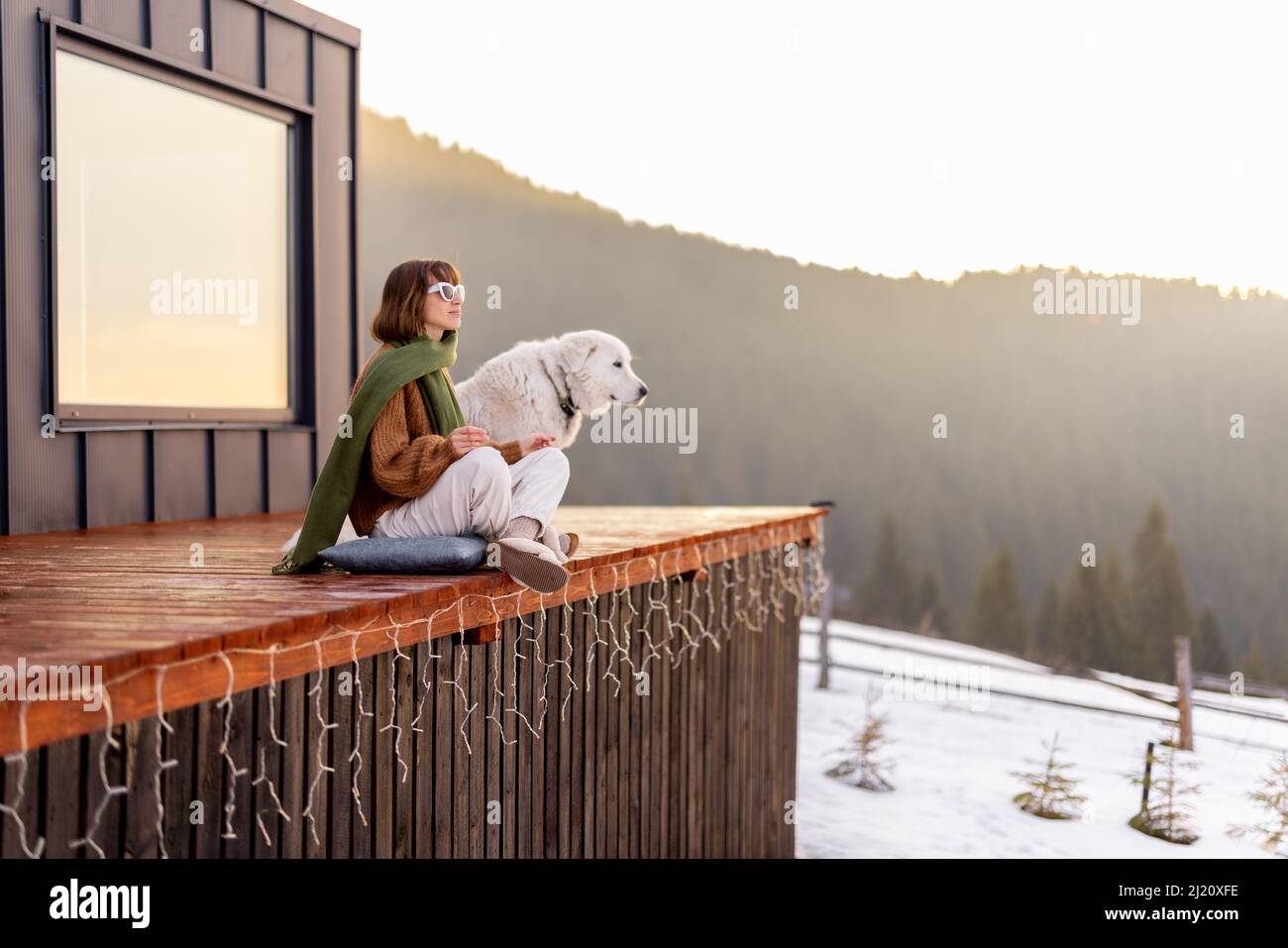 Woman with her dog resting on terrace of tiny house on nature Stock ...