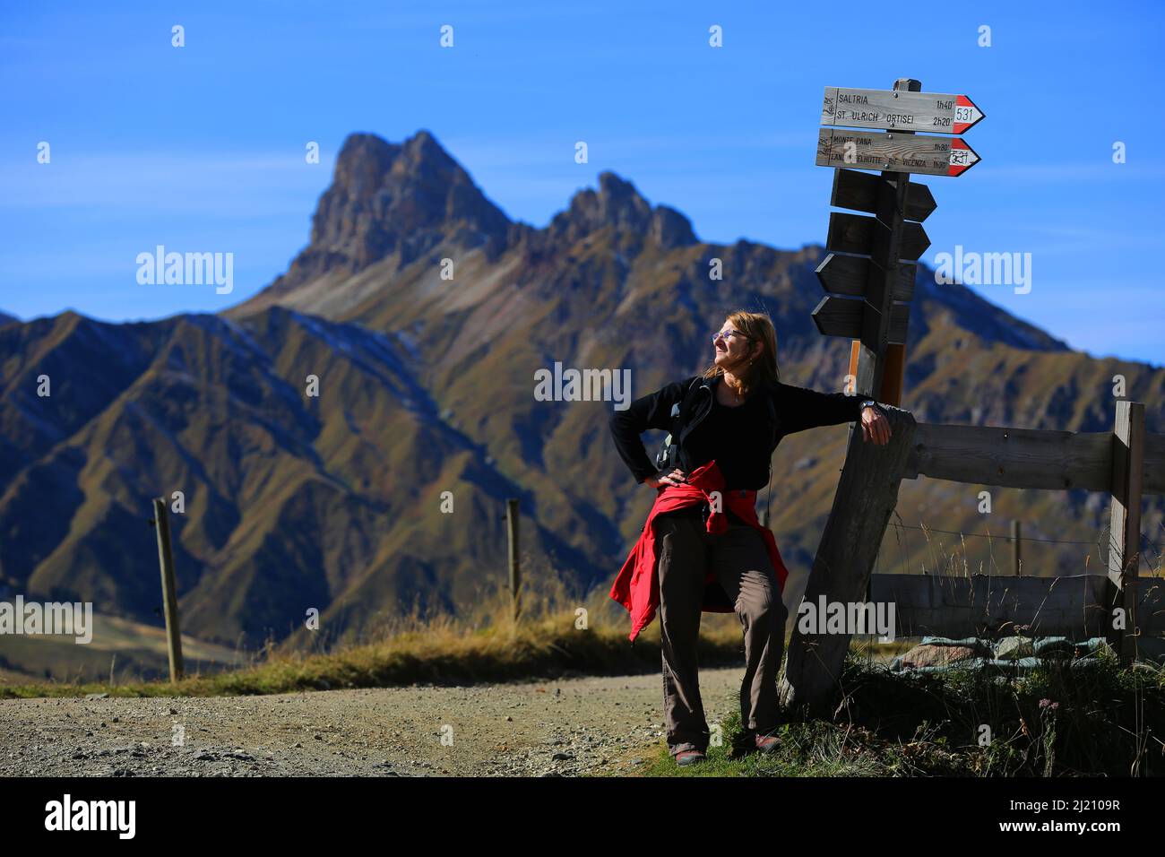 Dolomiten, schöne Frau beobachtet von der  Seiser Alm die  Berge und Felsen am  Langkofel oder Sasso Lungo in Südtirol in den Dolomiten Stock Photo