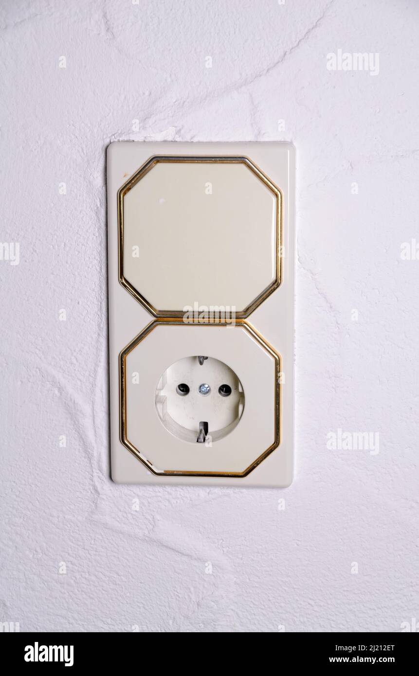 Modern light switch and german power outlet or socket on white wall indoors, Germany, Europe Stock Photo