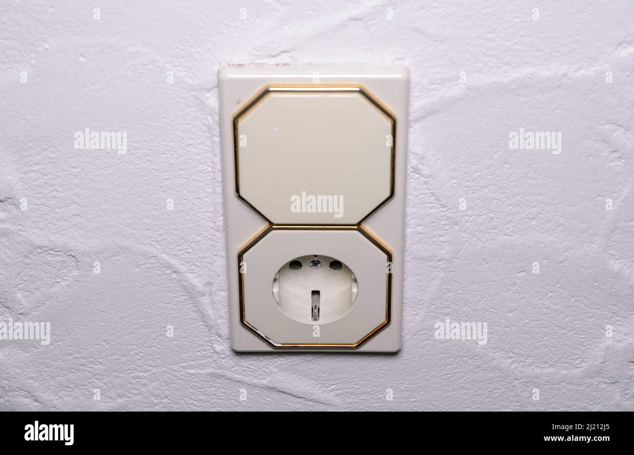 Modern light switch and german power outlet or socket on white wall indoors, Germany, Europe Stock Photo