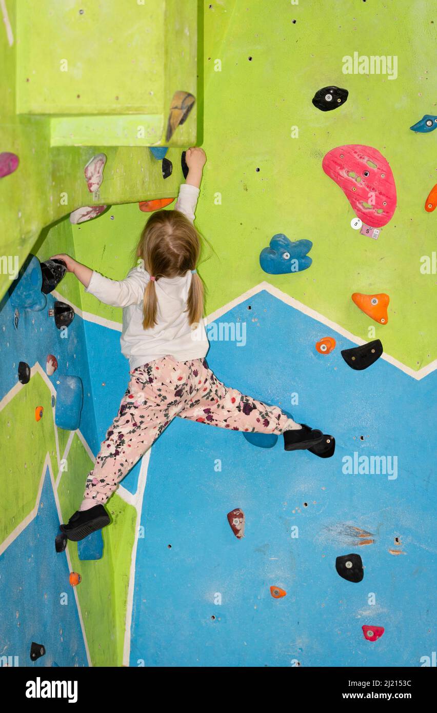 Young girl climbing and bouldering on a wall Stock Photo
