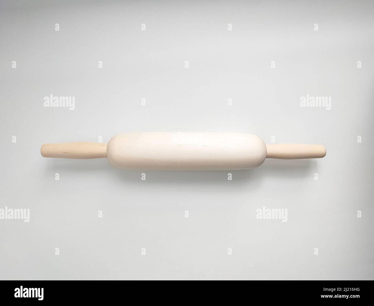 Rolling pin from natural wood on white background. Kitchen utensil