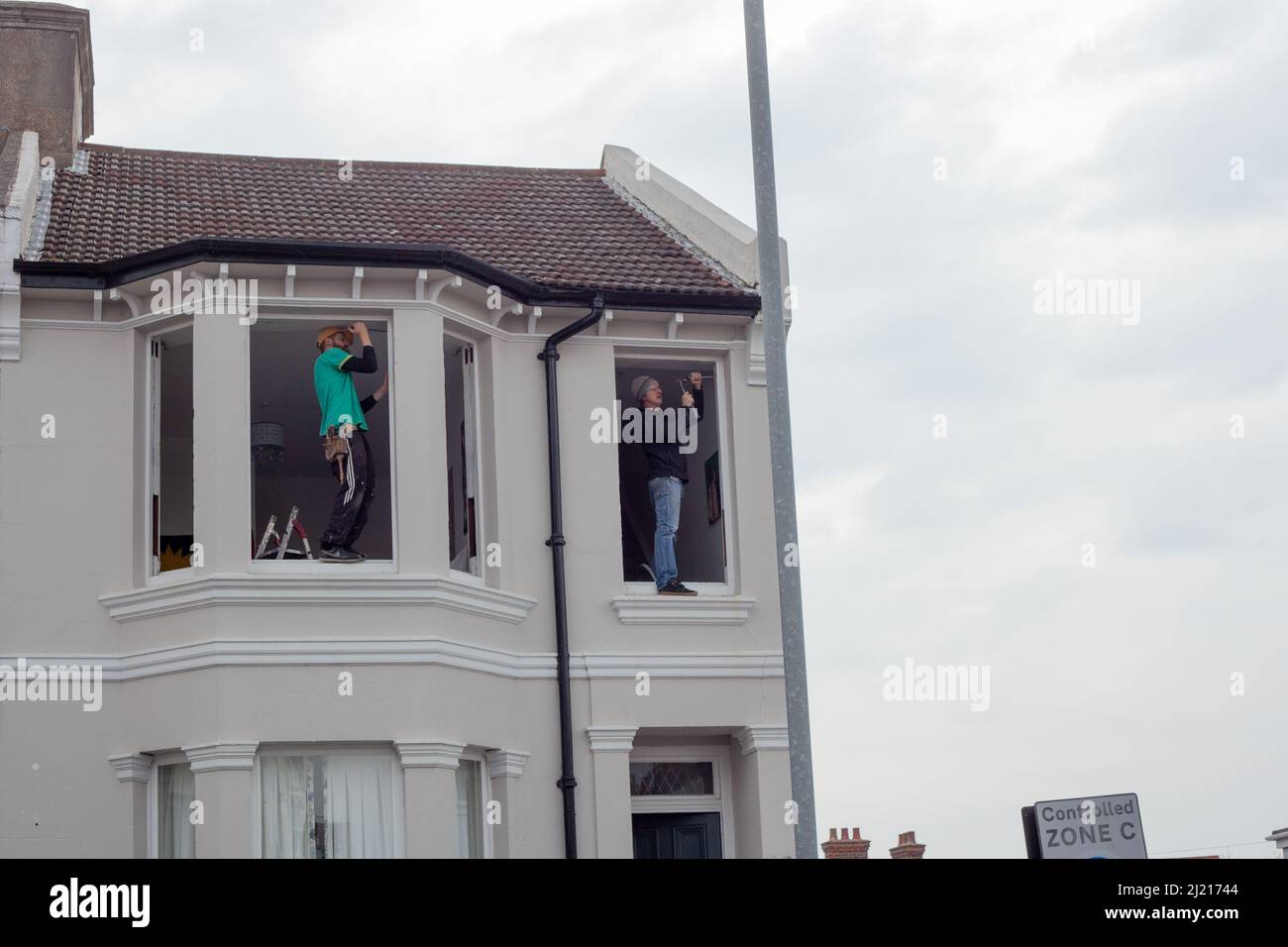 Two men replacing windows Stock Photo - Alamy