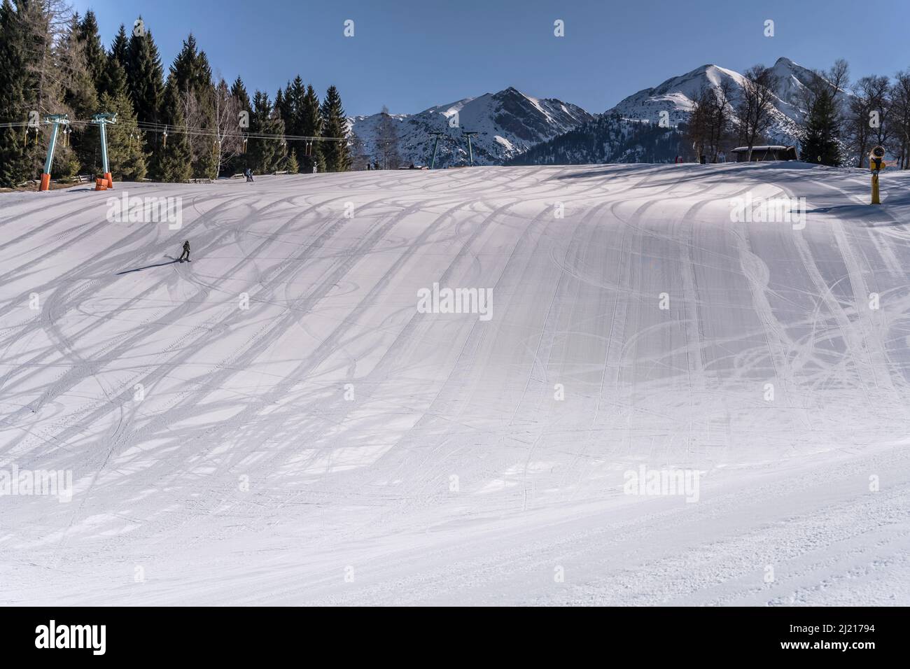 winter mountain landscape with winding ski marks  on snowy slope at Birkenlifte ski run, shot in bright light at Seefeld, Tyrol, Austria, Stock Photo