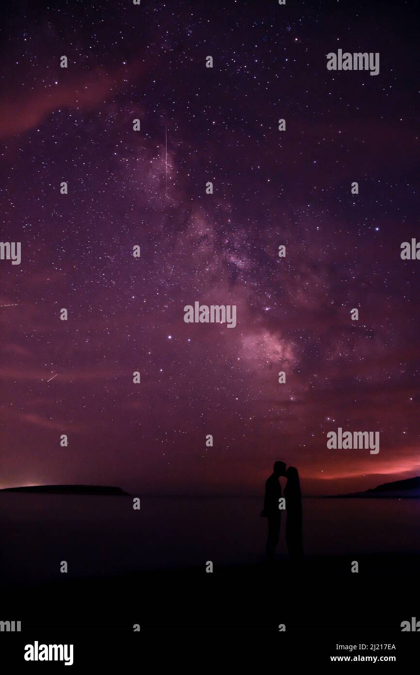 Lovers under the stars and milky way in the night sky. Stock Photo