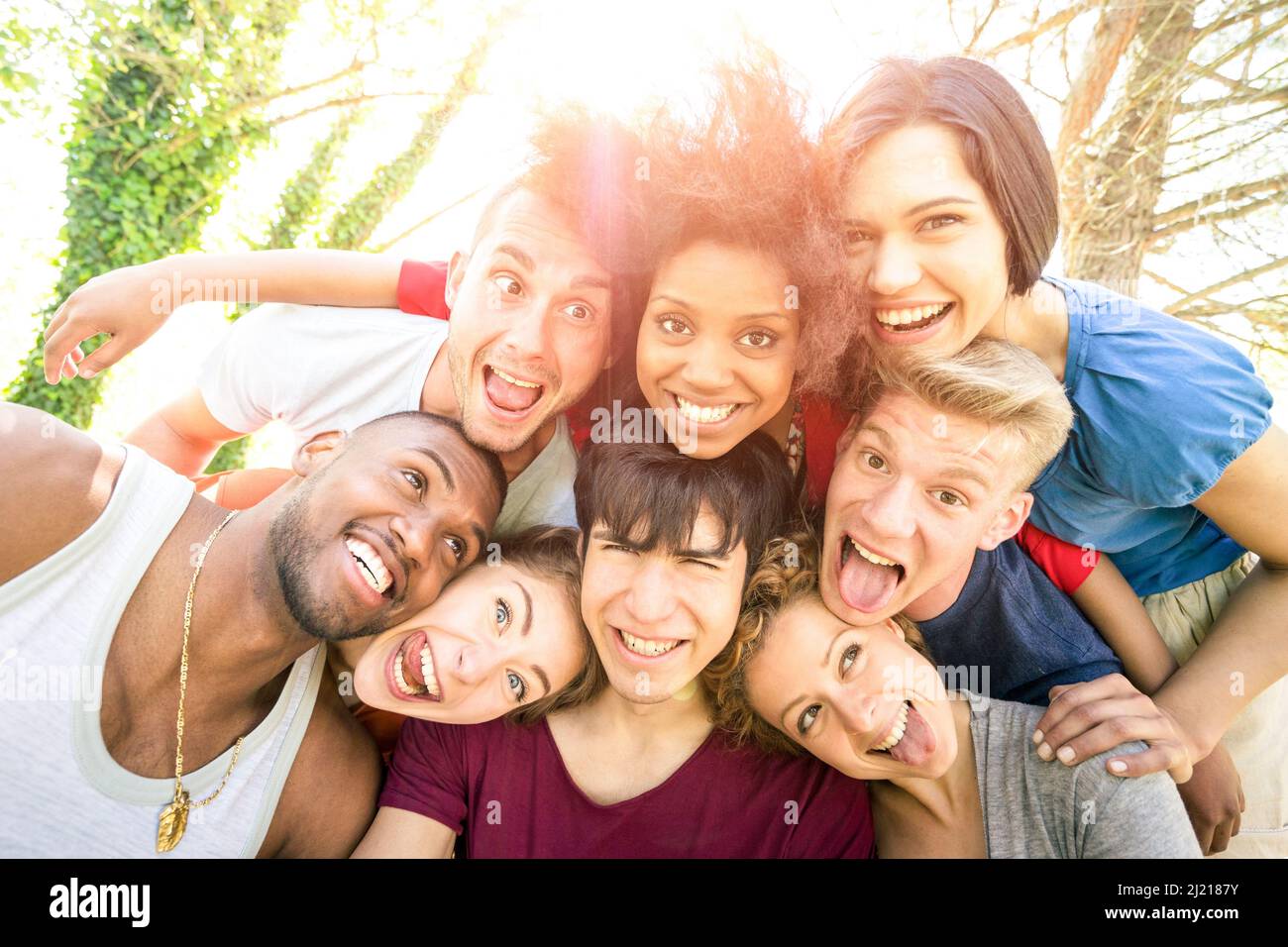 Best friends taking selfie outdoor with back lighting - Happy youth concept with young people having fun together - Cheer and friendship concept Stock Photo