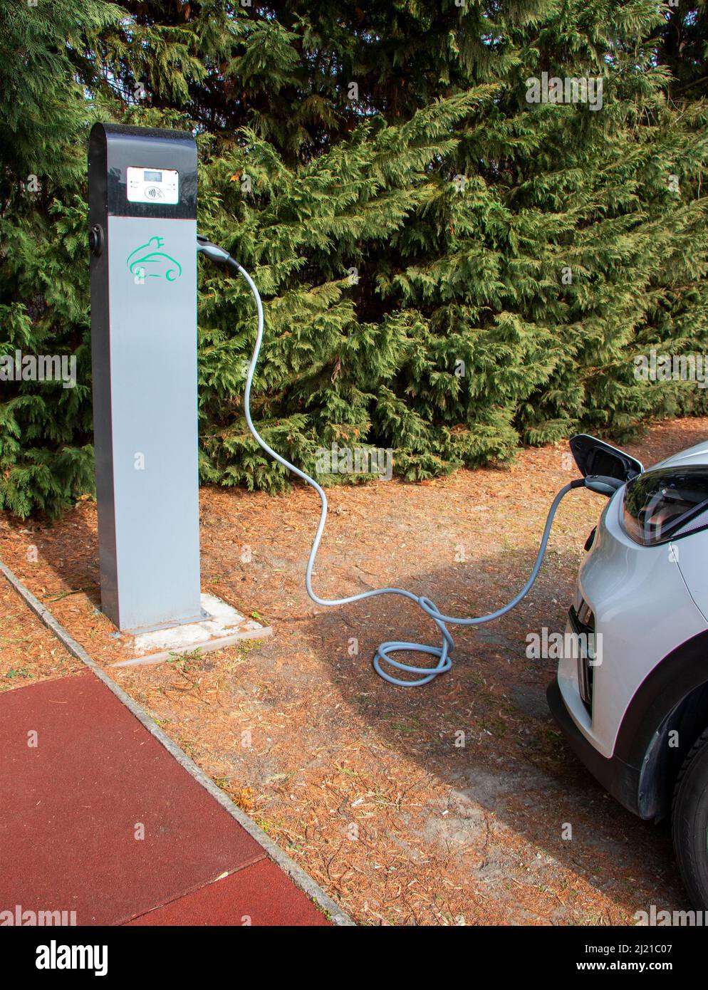 Electric Car With Charging Station In The Process Of Charging Stock electric-car-with-charging-station-in-the-process-of-charging-stock