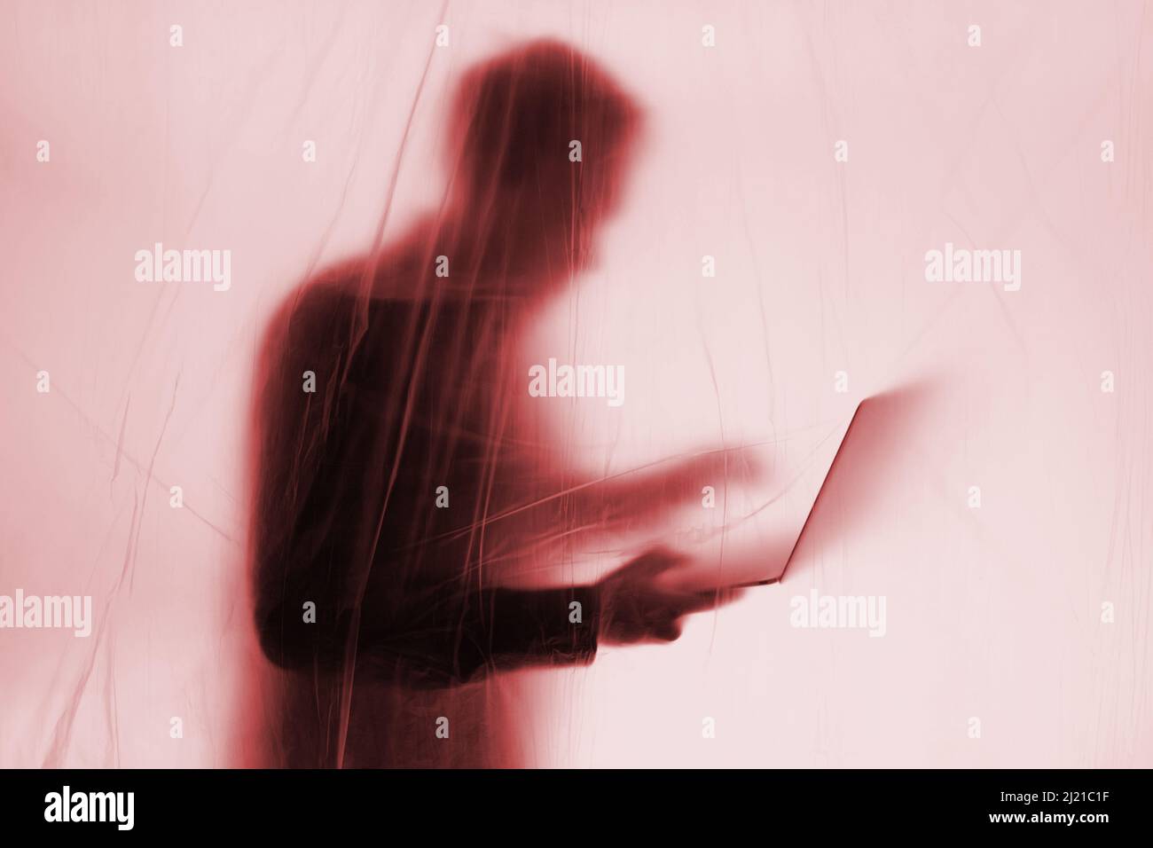 Anonymous Hacker commits cyber crime with laptop held in hand Stock Photo
