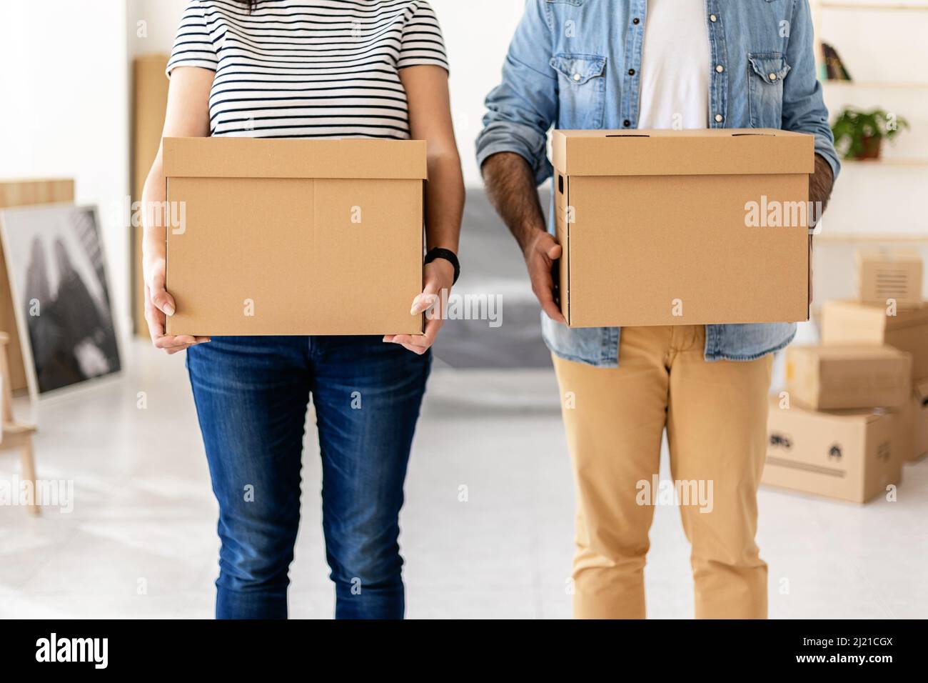 Young couple carrying cardboard boxes at new home before unpacking Stock Photo
