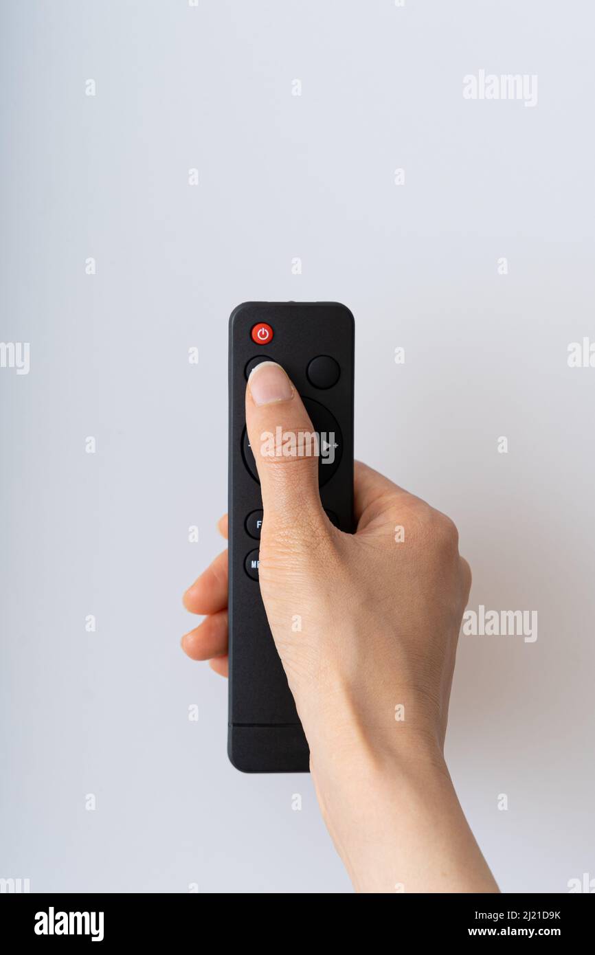 Asian hand operating remote control on white background Stock Photo - Alamy