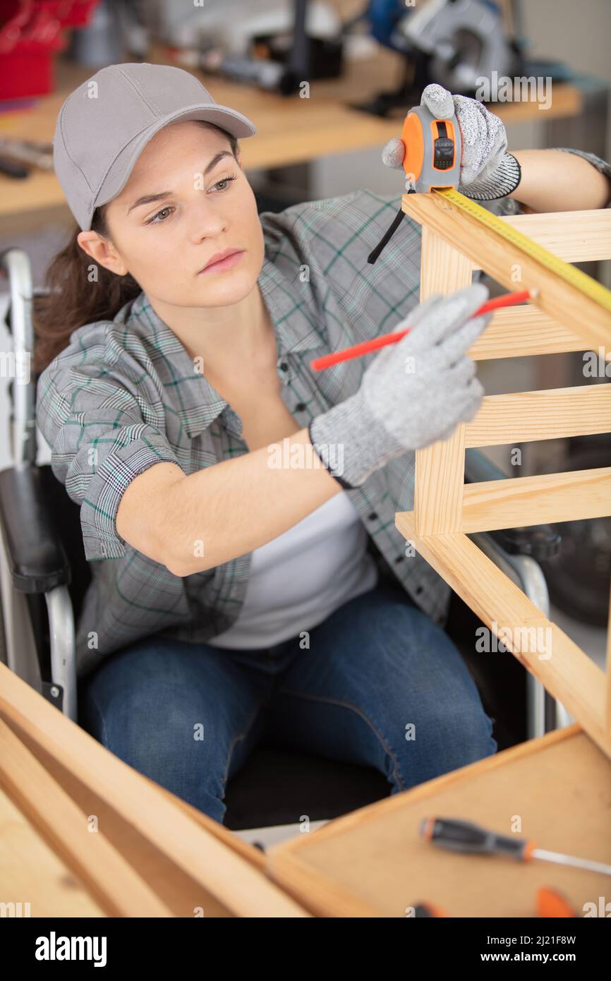 female repairman carpenter cutting joining wooden planks Stock Photo