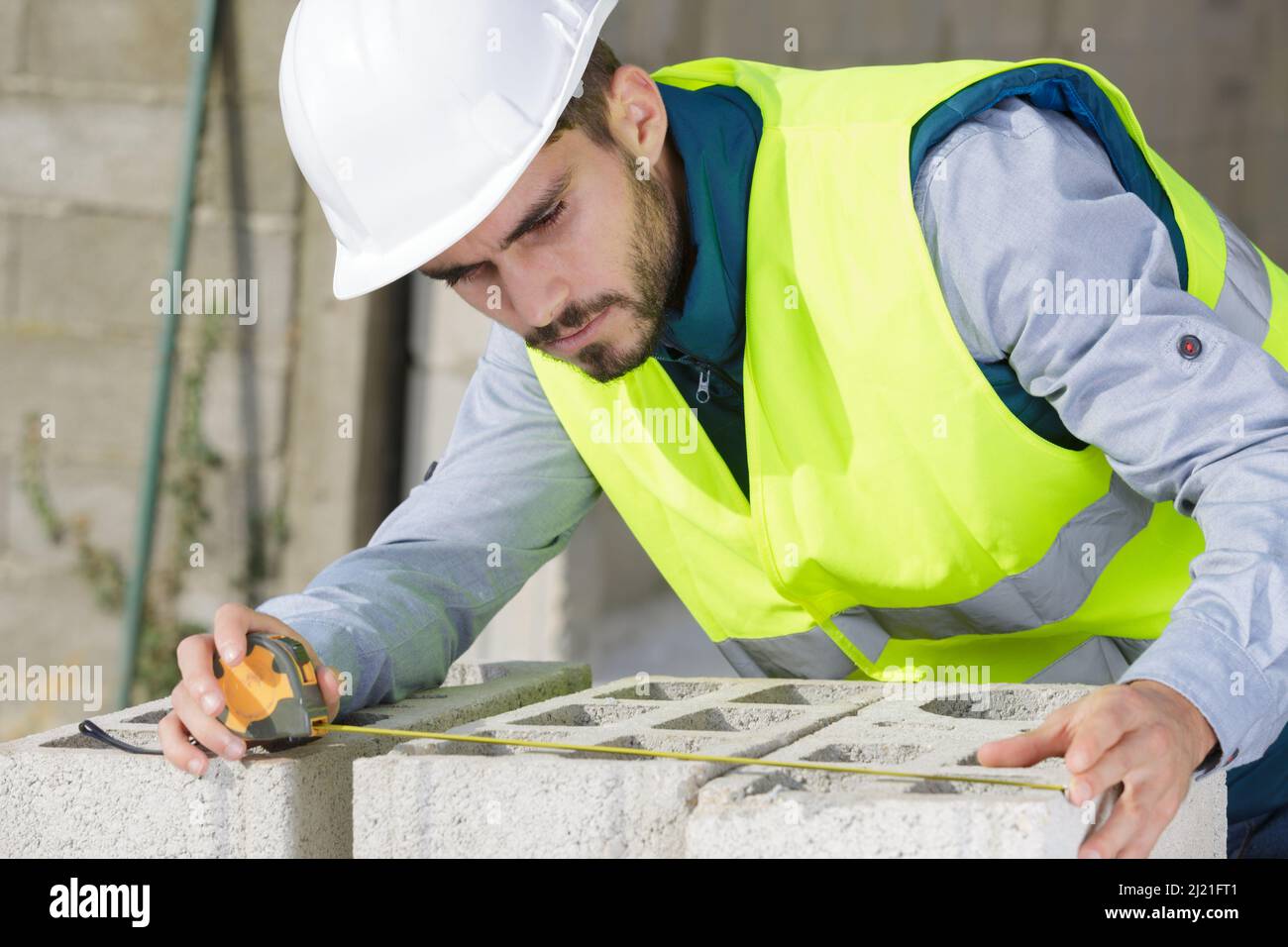 brickmason calculating the distance between bricks Stock Photo