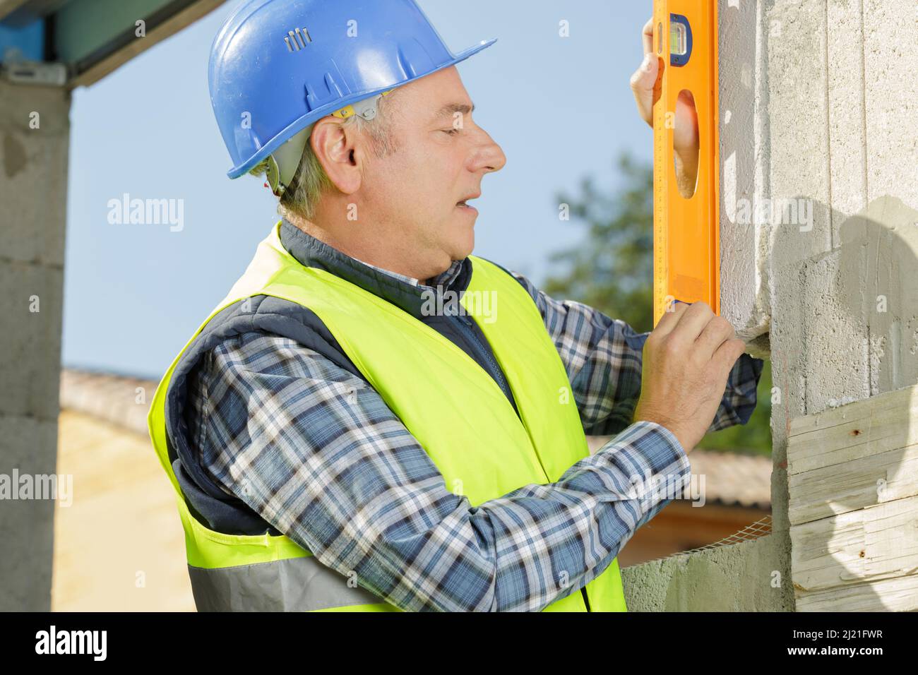 senior man using spirit level on wall Stock Photo - Alamy